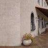 Epoca Marmo marmorino finish Facade of a building with decorative window grills and potted plants.